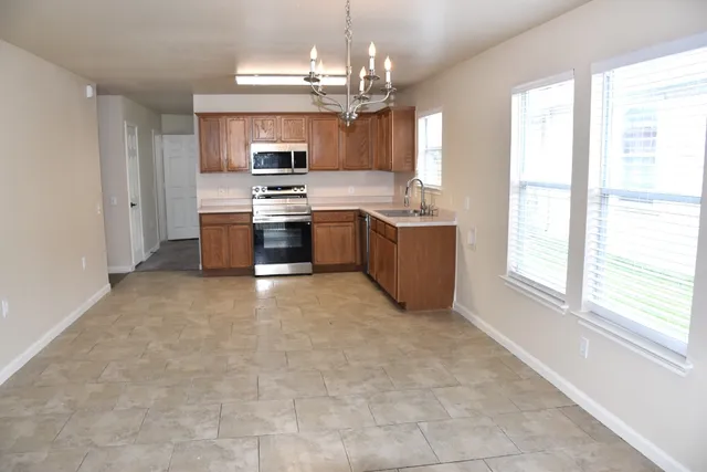 a large kitchen with a large window and stainless steel appliances