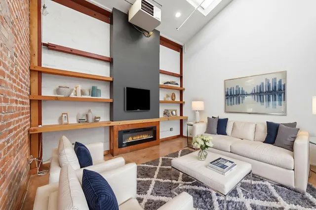 a living room with furniture a flat screen tv and a bookshelf