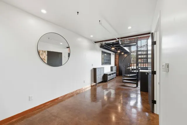 a view of a livingroom with wooden floor and a large window