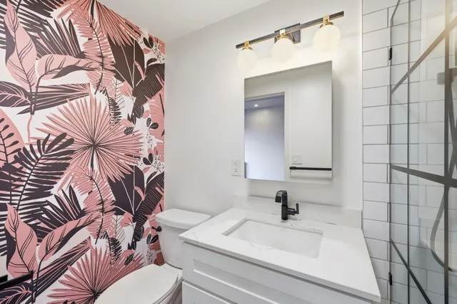 a bathroom with a sink a toilet and a mirror