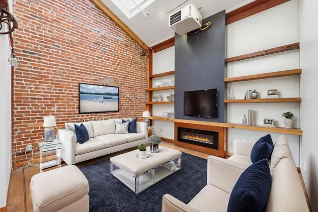 a living room with furniture a flat screen tv and a fireplace
