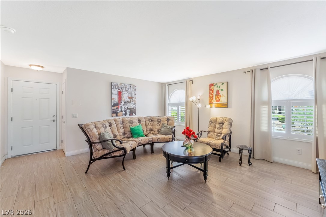 3145 East Flamingo Road, Unit 1092 Las Vegas, NV 89121 - Photo 2 of 33 Natural light floods this living space, highlighting its comfortable layout and sleek wood flooring.