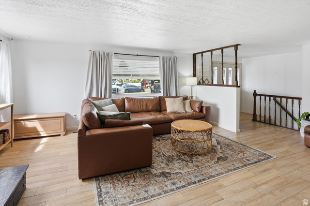5108 South 2000th Street West Roy, UT 84067 - Photo 5 of 61 Living room featuring light wood-style floors and a textured ceiling