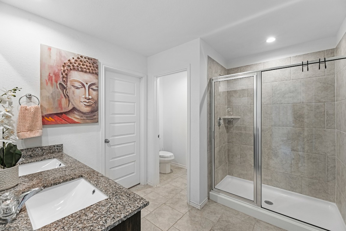 7534 Cynomys Court Rosharon, TX 77583 - Photo 18 of 35 a bathroom with a granite countertop sink a toilet and shower