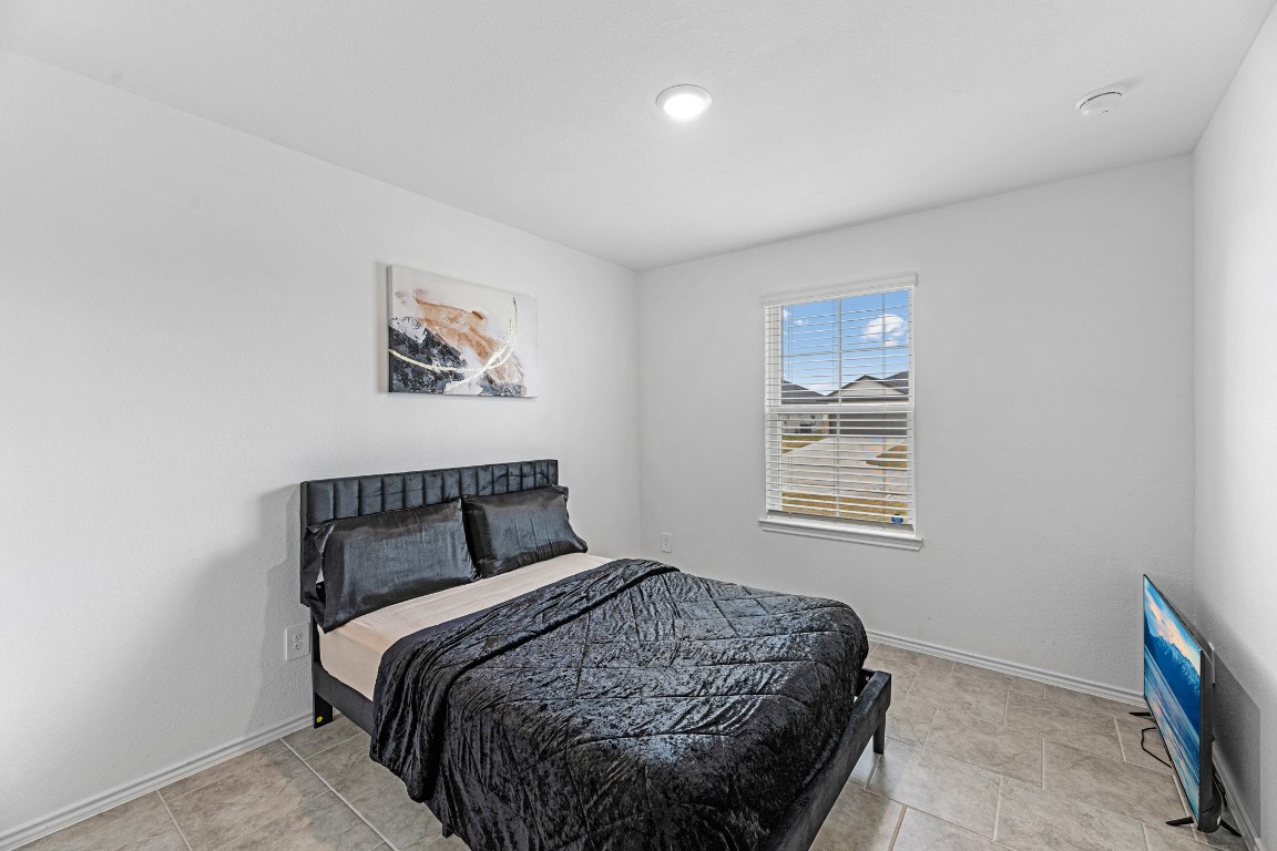 7534 Cynomys Court Rosharon, TX 77583 - Photo 22 of 35 a bedroom with a bed a window and painting on the wall