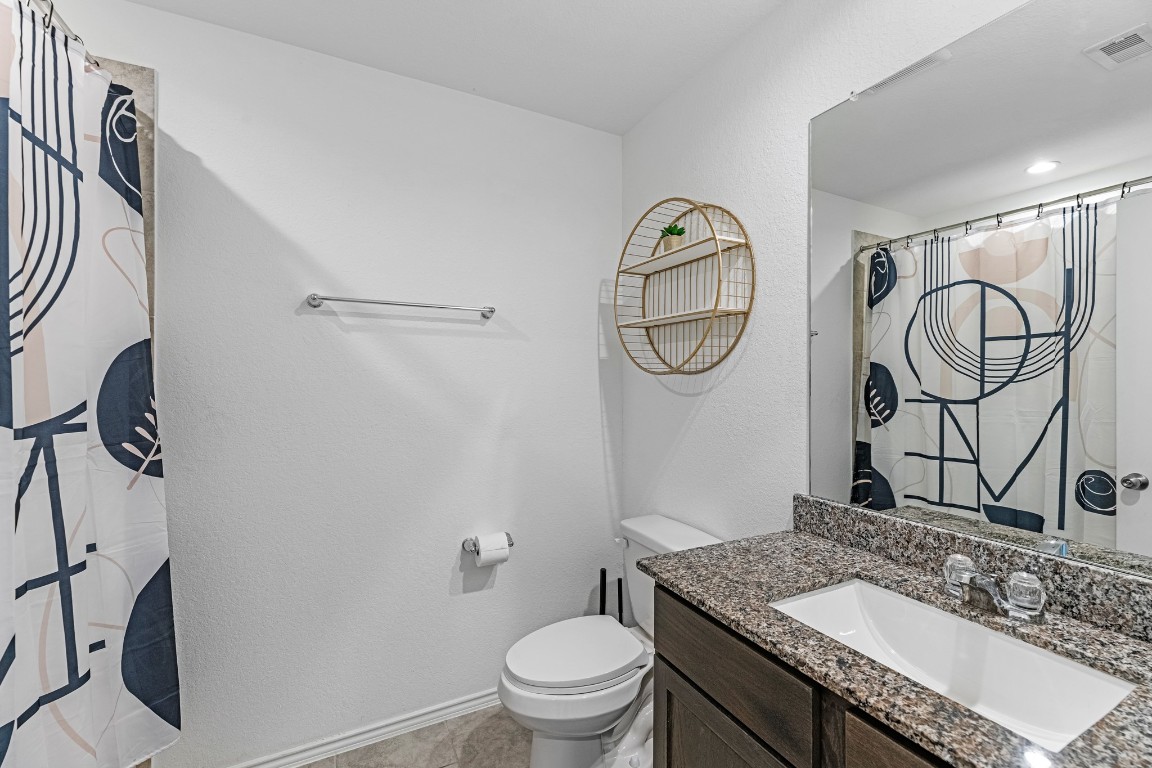 7534 Cynomys Court Rosharon, TX 77583 - Photo 24 of 35 a bathroom with a granite countertop toilet sink and mirror