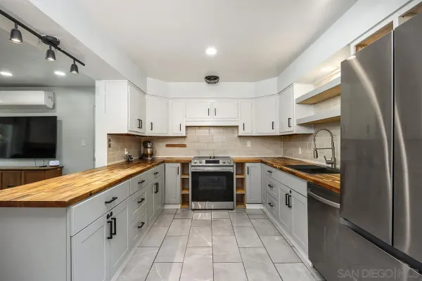 a kitchen with stainless steel appliances granite countertop a stove a sink and a refrigerator