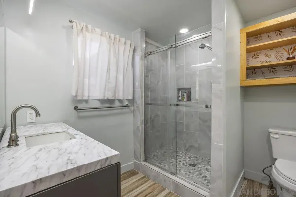 a bathroom with a sink a toilet and shower