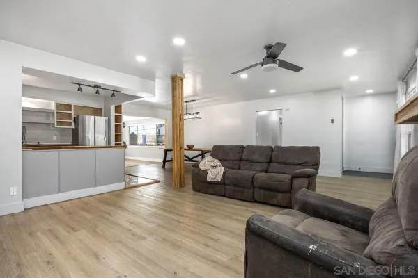 a living room with furniture and a view of kitchen