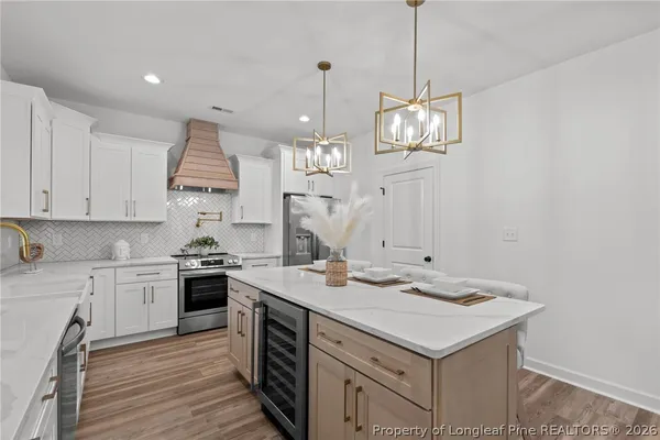 a kitchen that has a sink a stove and a wooden floors