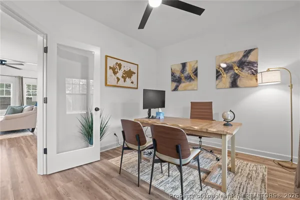 a view of a workspace with furniture and wooden floor