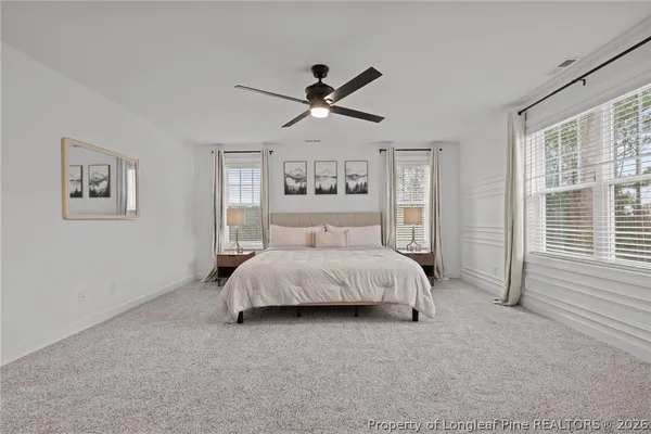 a spacious bedroom with a bed and a large window