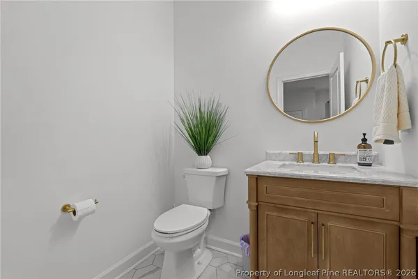 a bathroom with a granite countertop toilet a sink and a mirror