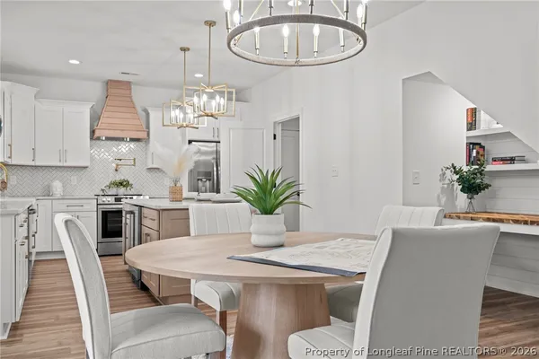 a dining room with furniture a kitchen and chandelier