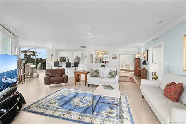 a living room with furniture a large window and kitchen view