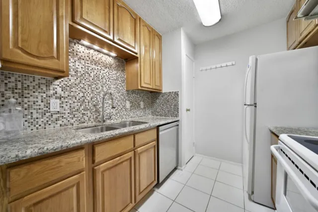 a kitchen with granite countertop white cabinets and white appliances