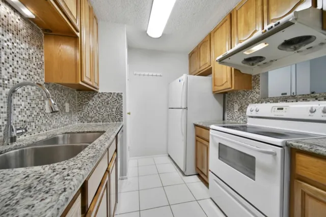 a kitchen with a stove a sink and a refrigerator