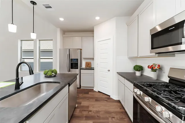 a kitchen with stainless steel appliances granite countertop a sink stove and refrigerator
