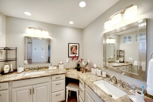 a bathroom with a sink double vanity granite and a mirror