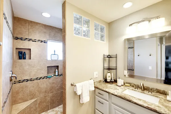 a bathroom with a granite countertop sink mirror and double
