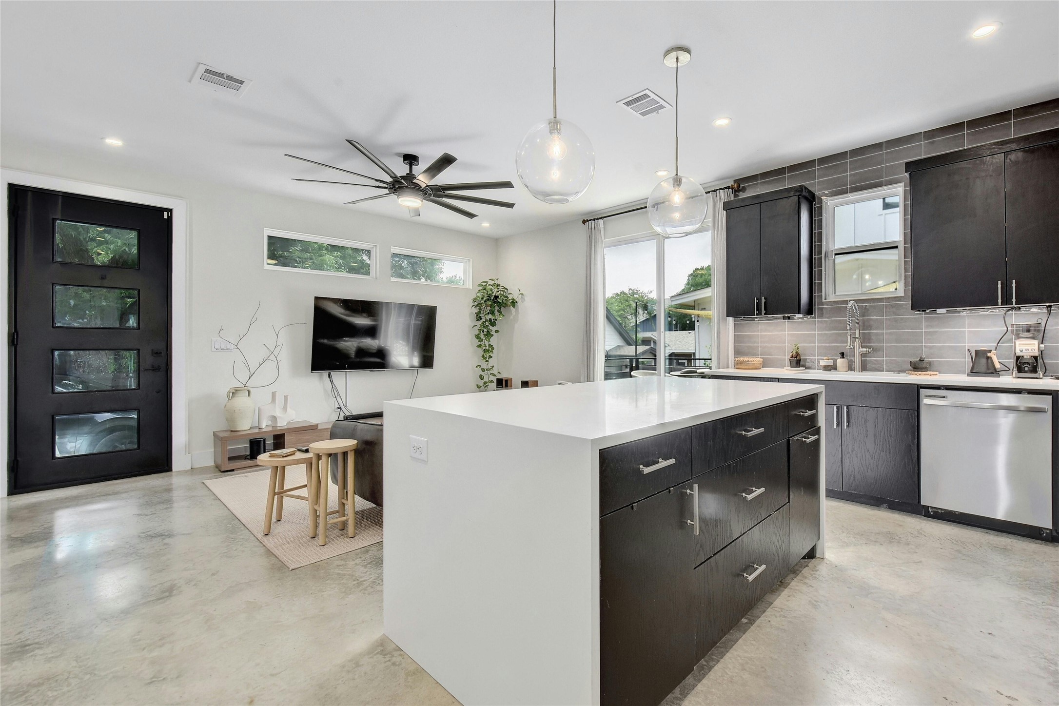 4606 Ledesma Road, Unit 2 Austin, TX 78721 - Photo 11 of 33 An open concept living area boasts a sleek kitchen island and modern appliances, flowing into a comfortable living space.