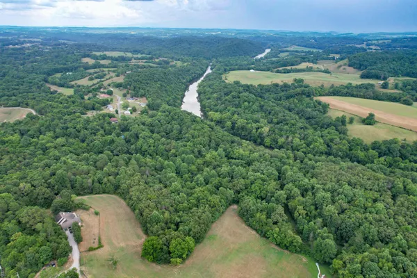 an aerial view of a house with a yard and lake view