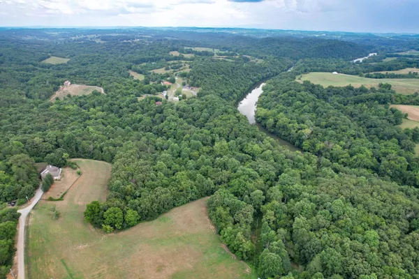 an aerial view of a house with a yard and lake view
