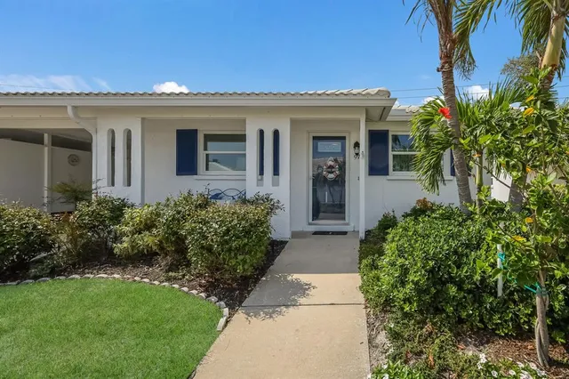 a view of a house with a large window and potted plants