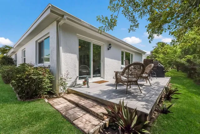 a view of a deck with couches table and chairs and potted plants