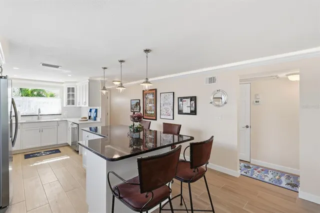 a kitchen with a dining table chairs and white cabinets