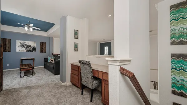 a view of a hallway with workspace and windows