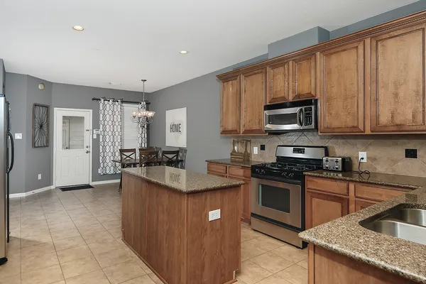 a kitchen with stainless steel appliances granite countertop a sink a stove and a refrigerator
