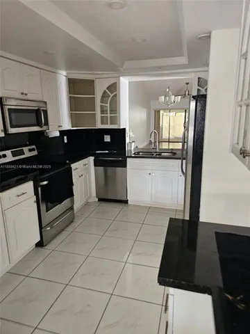 a kitchen with granite countertop a stove a sink dishwasher and a refrigerator