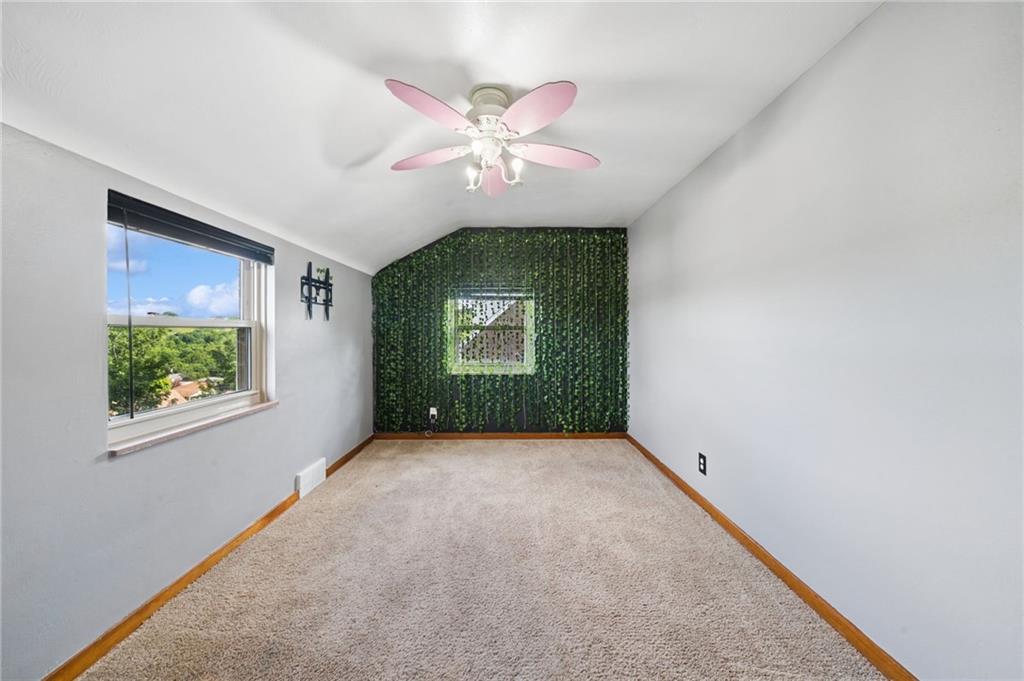 711 Jane Street Pittsburgh, PA 15239 - Photo 12 of 27 Another view of the charming second bedroom offers a bright layout with neutral carpeting and a bold accent wall with integrated lighting, a ceiling fan, and great natural light.