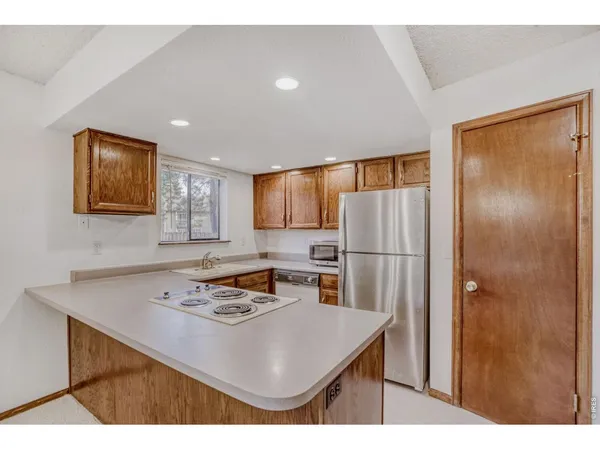 a kitchen with kitchen island a counter top space cabinets and stainless steel appliances