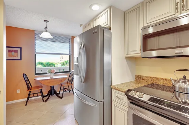 a kitchen with stainless steel appliances granite countertop a stove a refrigerator and a microwave