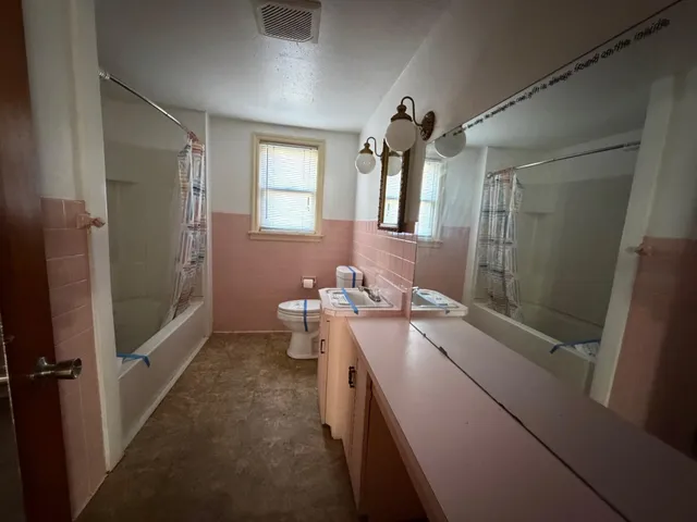 a bathroom with a double vanity sink toilet and shower