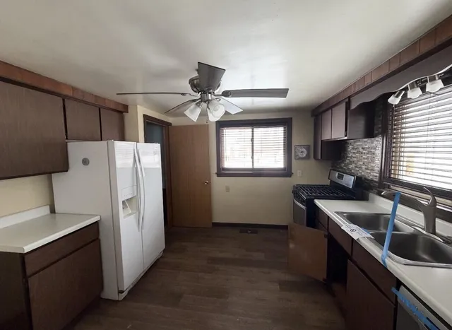 a kitchen with stainless steel appliances granite countertop a sink stove and refrigerator
