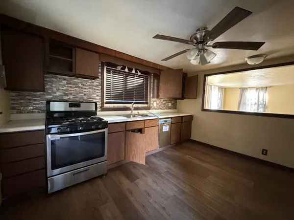 a kitchen with stainless steel appliances kitchen island granite countertop a stove and a sink