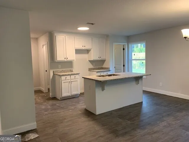 an open kitchen with kitchen island white cabinets and stainless steel appliances