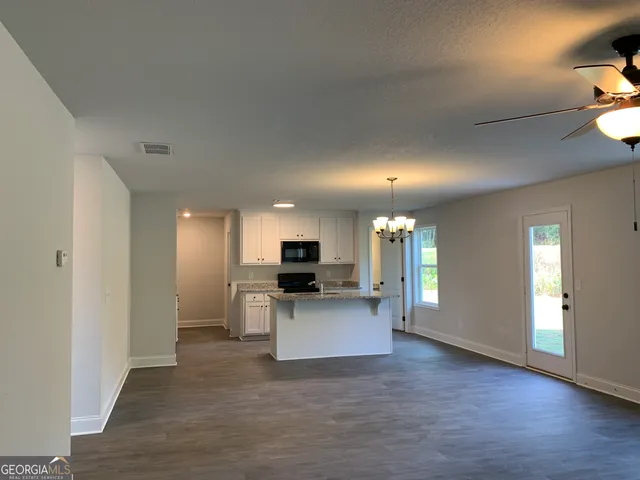 a view of a kitchen with a sink a refrigerator a microwave and a refrigerator