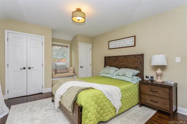 a bedroom with a bed and a lamp on dresser