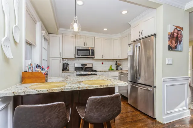 a kitchen with stainless steel appliances granite countertop a refrigerator a stove a sink dishwasher a microwave oven with granite countertops and cabinets