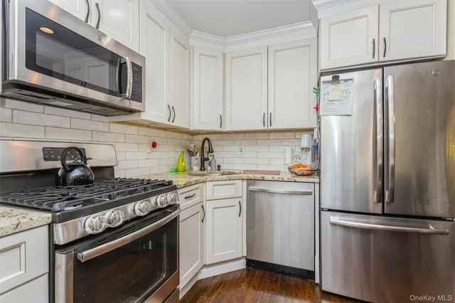 a kitchen with stainless steel appliances a refrigerator stove and microwave