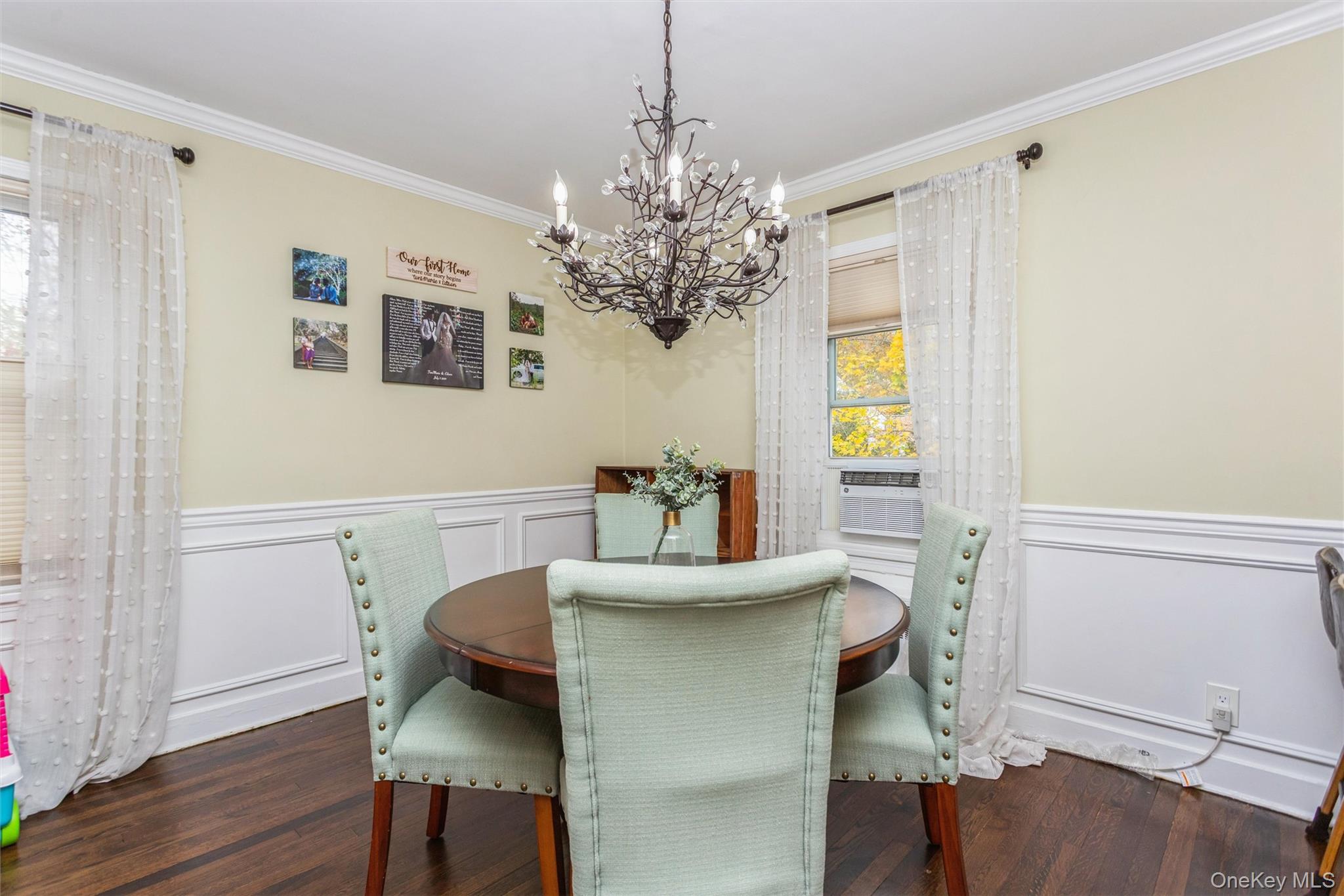 35 Peck Avenue, Unit 35A Rye, NY 10580 - Photo 8 of 27 Dining area with crown molding, a decorative wall, wainscoting, a chandelier, and dark wood-style flooring