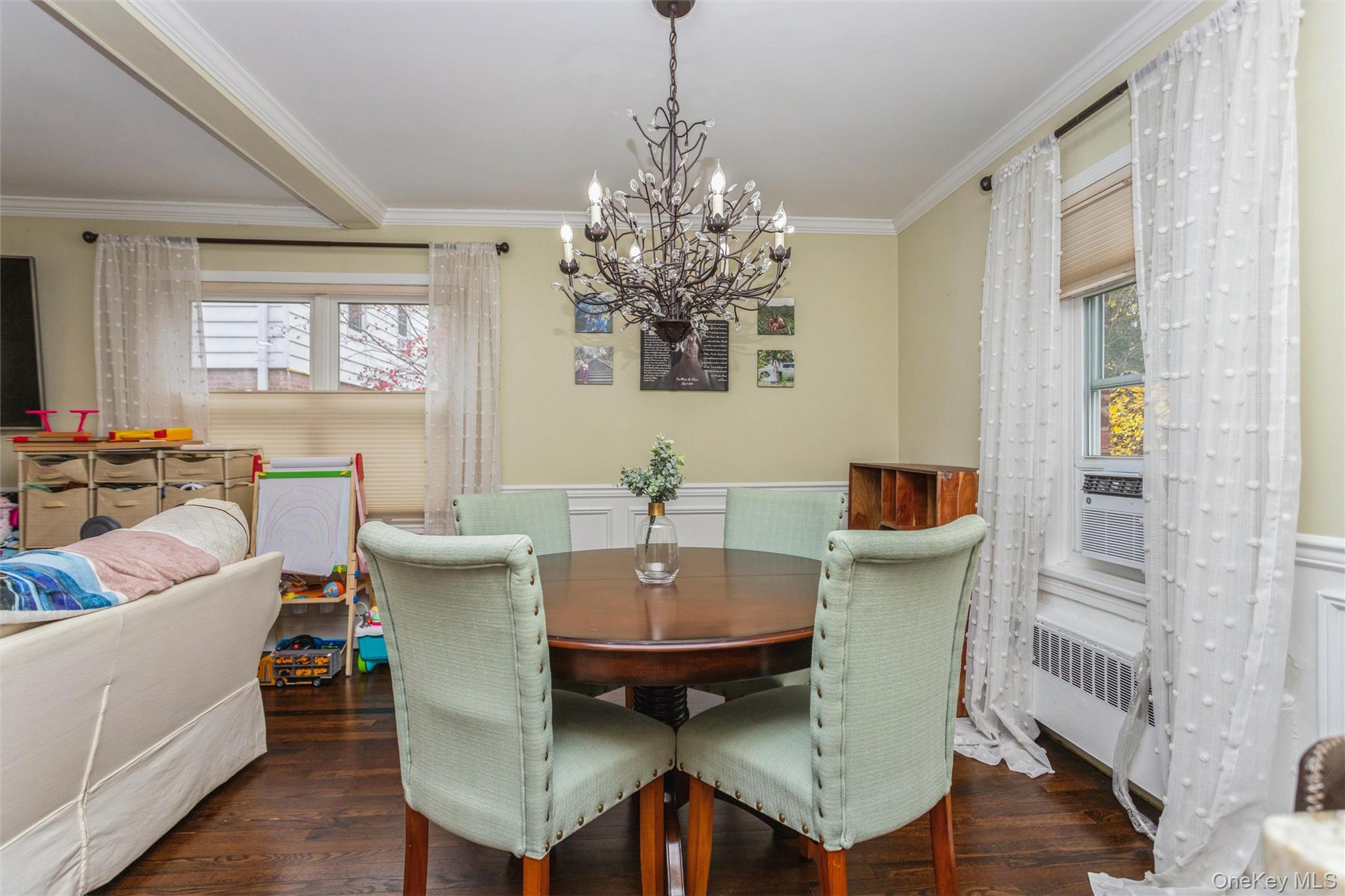 35 Peck Avenue, Unit 35A Rye, NY 10580 - Photo 9 of 27 Dining area featuring dark wood finished floors, ornamental molding, radiator, a chandelier, and wainscoting