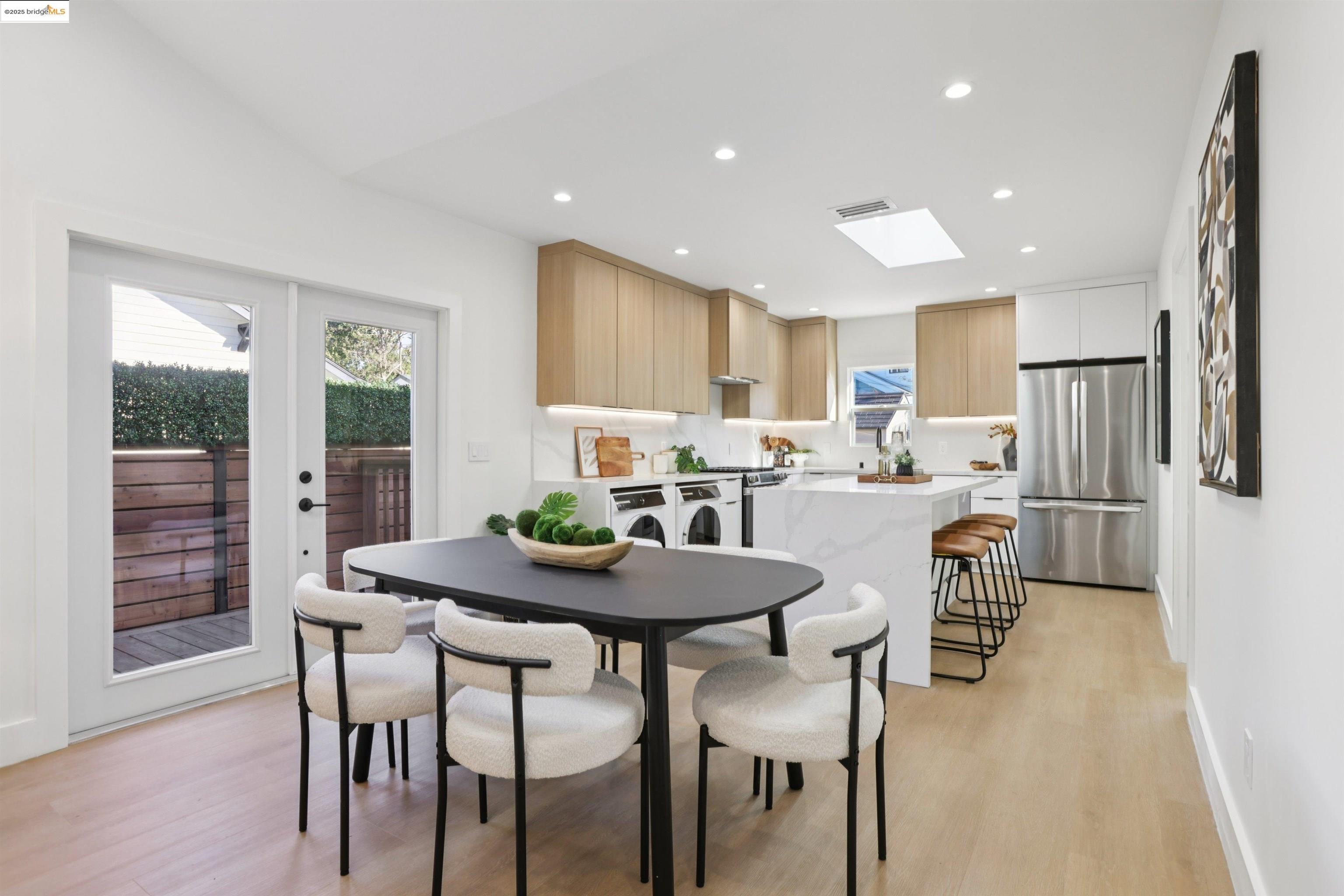 1612 Carleton Street Berkeley, CA 94703 - Photo 9 of 35 a kitchen with stainless steel appliances kitchen island granite countertop a dining table chairs and refrigerator