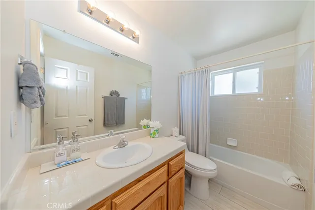 a spacious bedroom with a bed and a chandelier