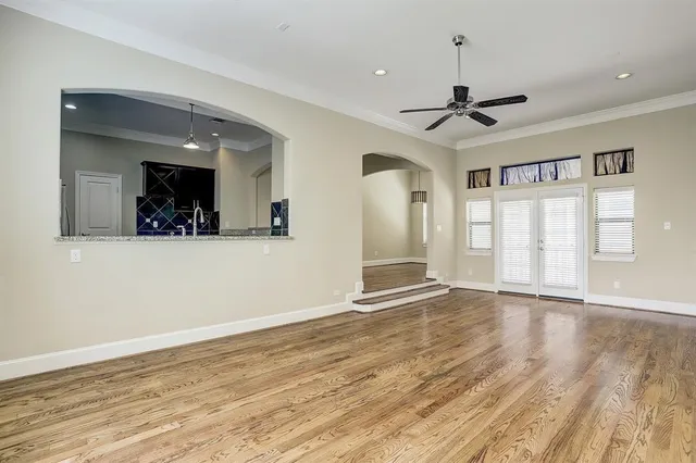 a view of an empty room with window and wooden floor