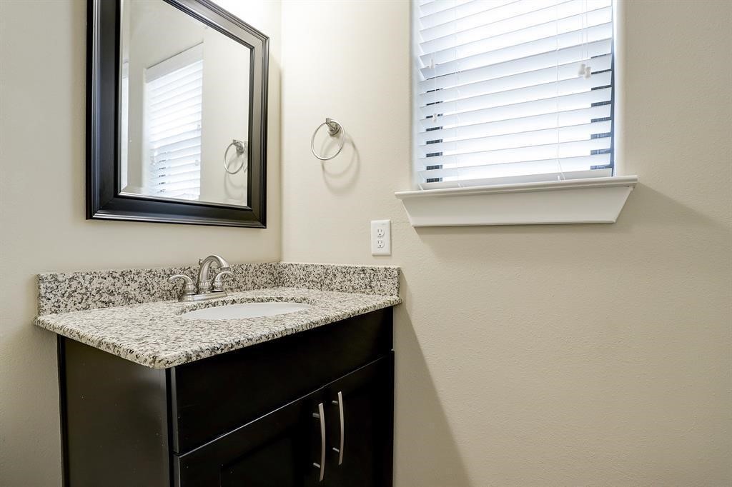 1601 West 24th Street, Unit A Houston, TX 77008 - Photo 16 of 28 a bathroom with a granite countertop sink and a mirror